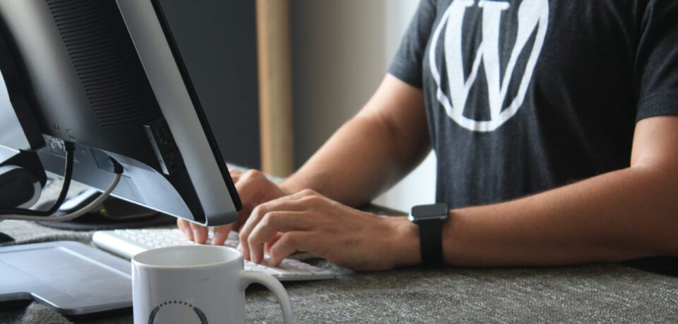 person in black and white t-shirt using computer